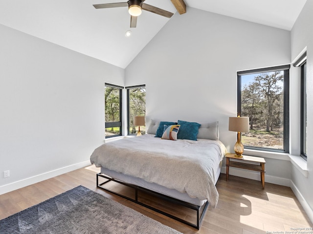 bedroom featuring light wood-type flooring, baseboards, high vaulted ceiling, and beamed ceiling