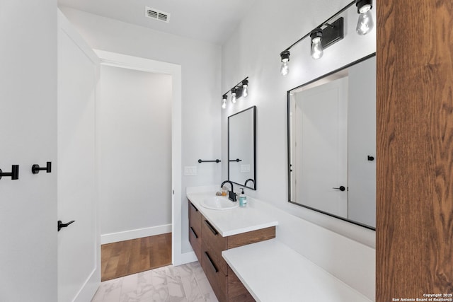 bathroom featuring marble finish floor, visible vents, vanity, and baseboards