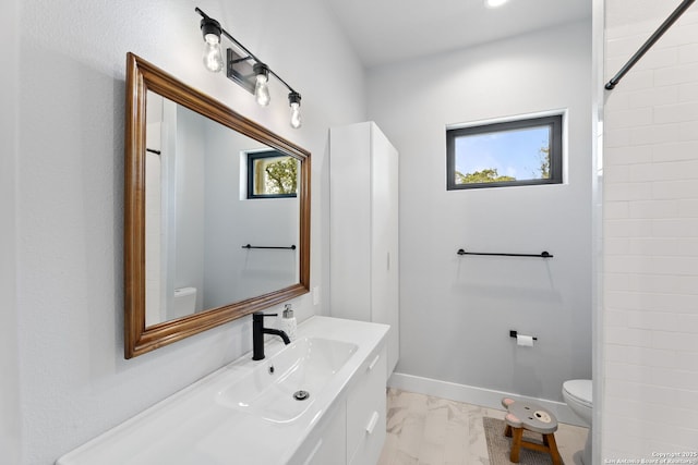 bathroom featuring marble finish floor, vanity, toilet, and baseboards