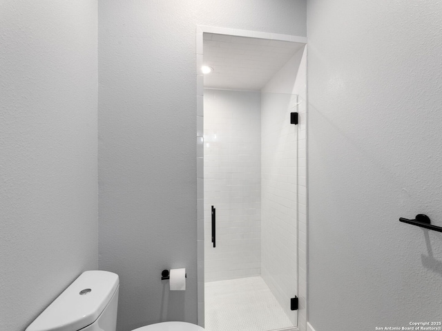 bathroom with a stall shower and toilet