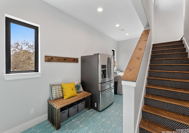 stairs featuring baseboards, visible vents, washer / dryer, and recessed lighting