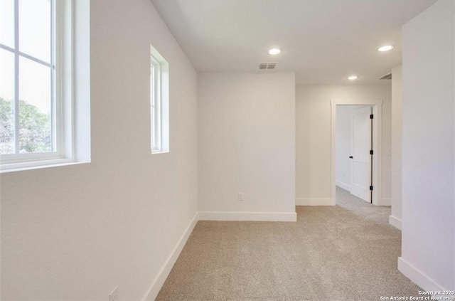 unfurnished room with recessed lighting, visible vents, light carpet, and baseboards