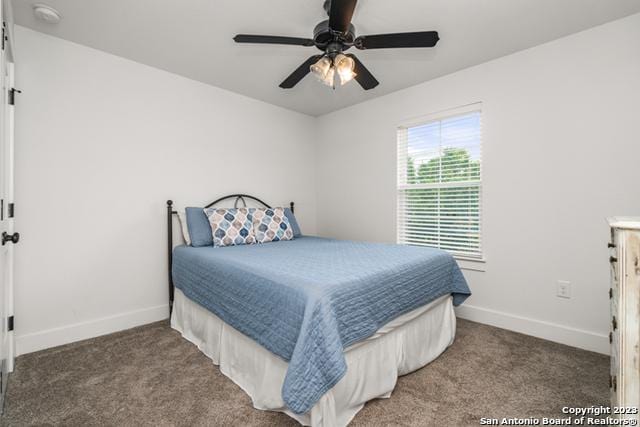 carpeted bedroom with ceiling fan and baseboards