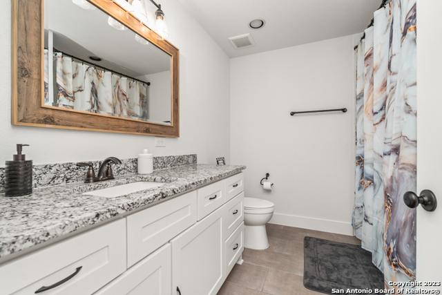 full bathroom featuring toilet, baseboards, visible vents, and vanity