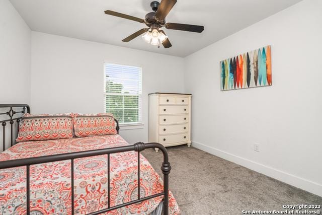 carpeted bedroom with ceiling fan and baseboards