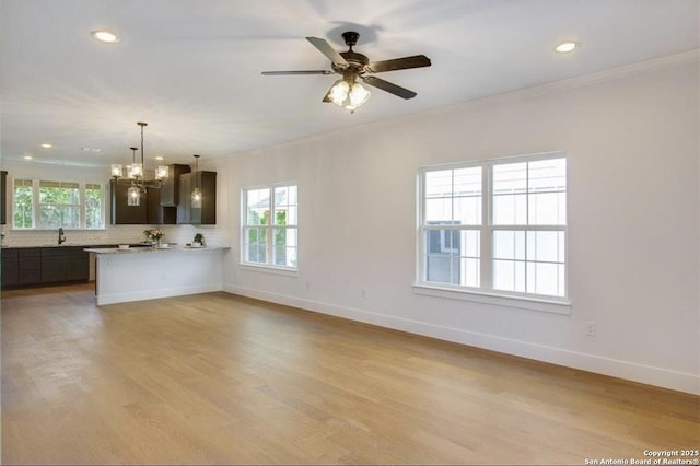 kitchen featuring ornamental molding, light countertops, light wood finished floors, and baseboards