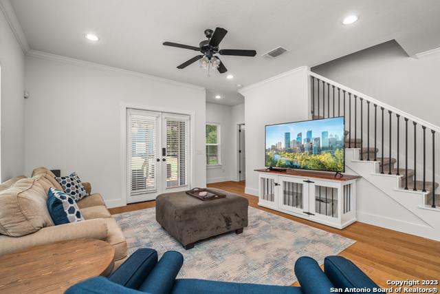 living room featuring visible vents, ornamental molding, wood finished floors, stairs, and recessed lighting