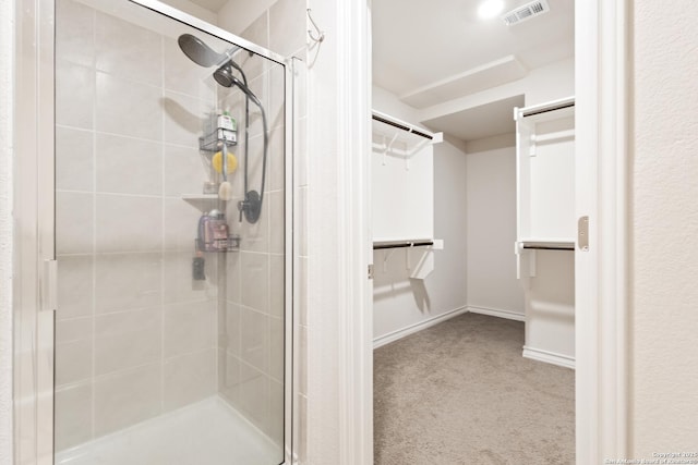 full bathroom with a stall shower, baseboards, a spacious closet, and visible vents