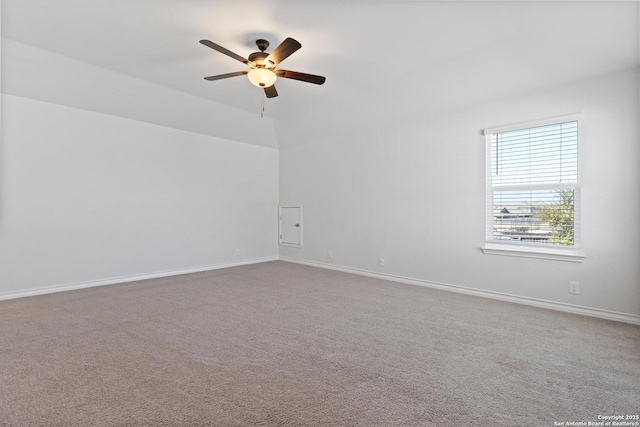 carpeted spare room featuring baseboards and a ceiling fan