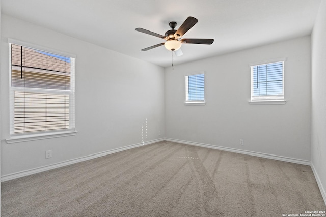 carpeted empty room with ceiling fan and baseboards