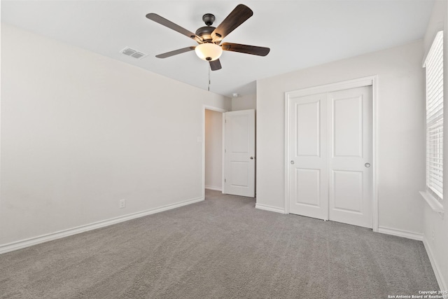 unfurnished bedroom with carpet, a closet, visible vents, and baseboards