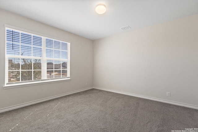 spare room with visible vents, baseboards, and carpet flooring