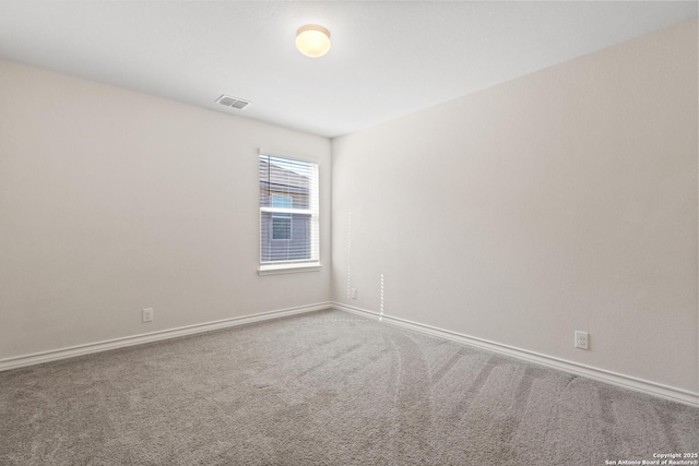 carpeted spare room featuring visible vents and baseboards