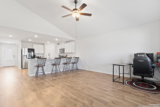 kitchen with stainless steel appliances, light wood-style floors, a peninsula, and a breakfast bar area