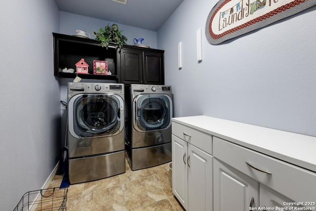 clothes washing area featuring visible vents, separate washer and dryer, cabinet space, and baseboards