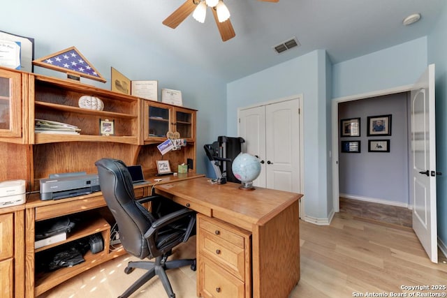 office area with light wood-style floors, visible vents, baseboards, and a ceiling fan