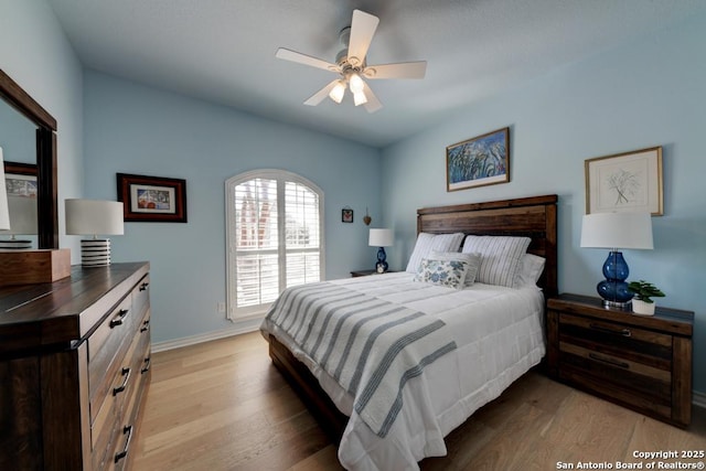 bedroom with a ceiling fan, light wood-type flooring, and baseboards