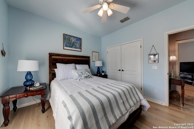 bedroom featuring a closet, wood finished floors, visible vents, and baseboards