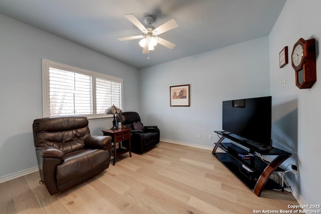 living area with light wood-style floors, ceiling fan, and baseboards