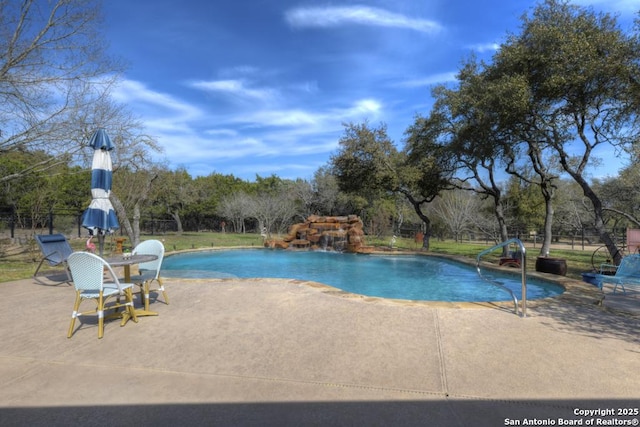 outdoor pool with a patio and fence