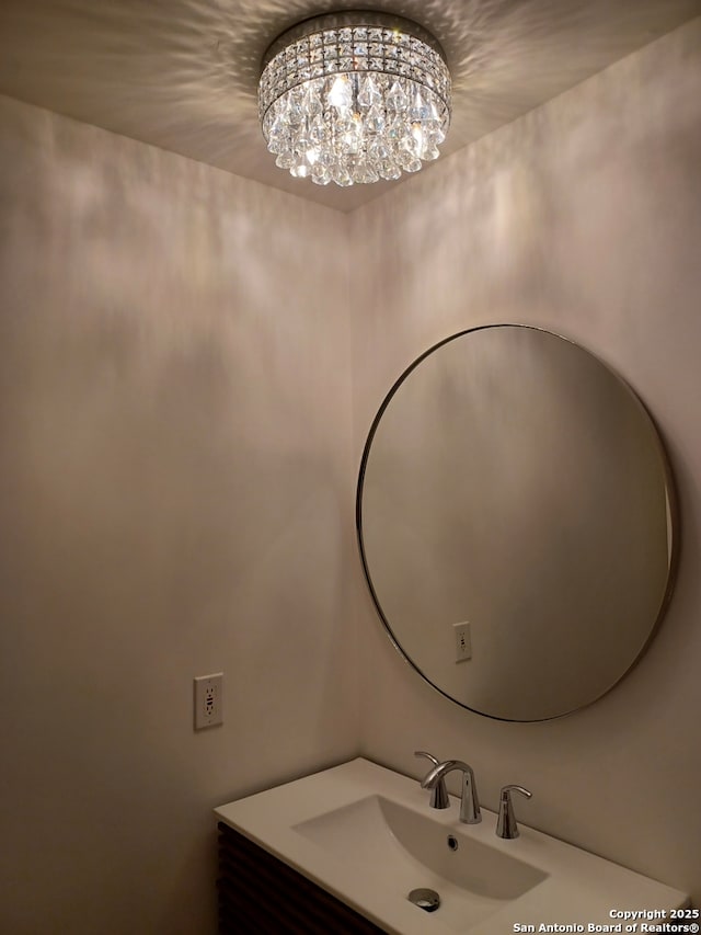 bathroom with a notable chandelier and a sink