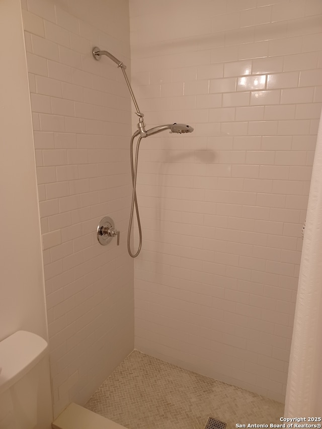 bathroom featuring a stall shower and toilet