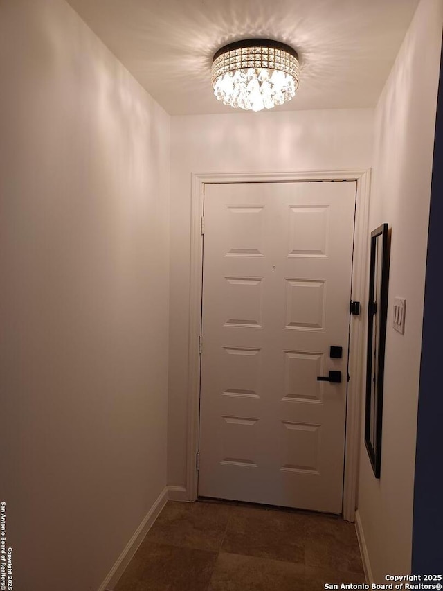 doorway to outside featuring baseboards