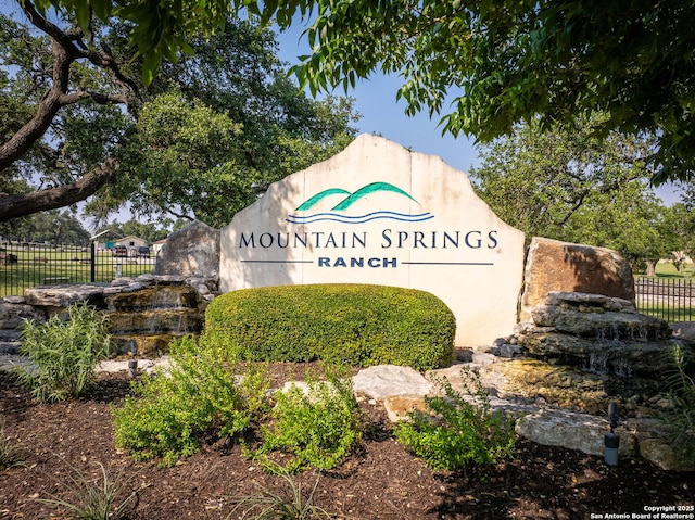 community / neighborhood sign with fence