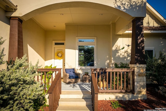 property entrance featuring a porch and stucco siding