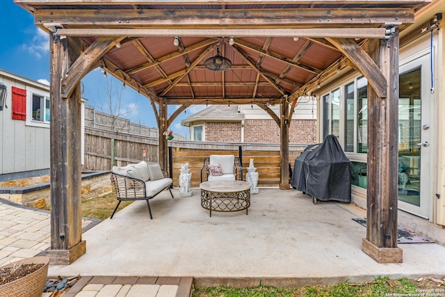 view of patio with a grill, fence, and a gazebo