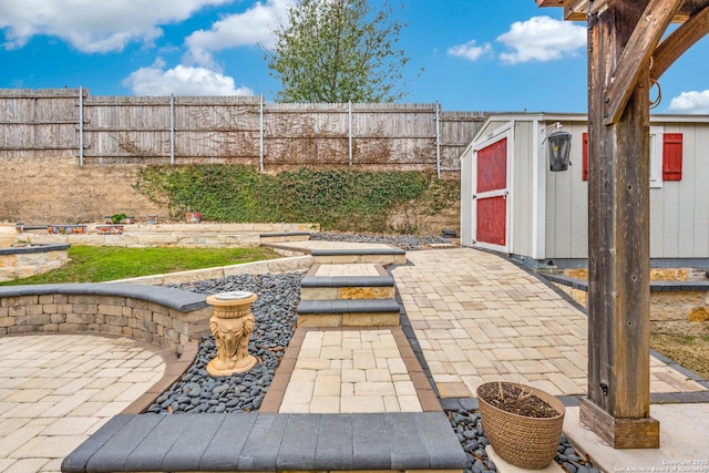 view of patio / terrace with a fenced backyard and an outdoor structure