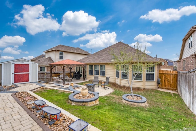 back of property featuring an outbuilding, a fire pit, a gazebo, a shed, and a patio area