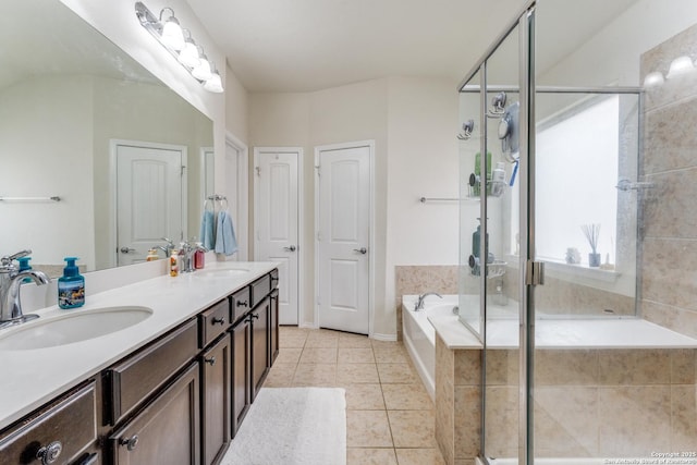 bathroom featuring a bath, a stall shower, a sink, and tile patterned floors