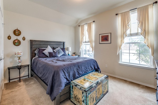 bedroom with vaulted ceiling, baseboards, and light colored carpet