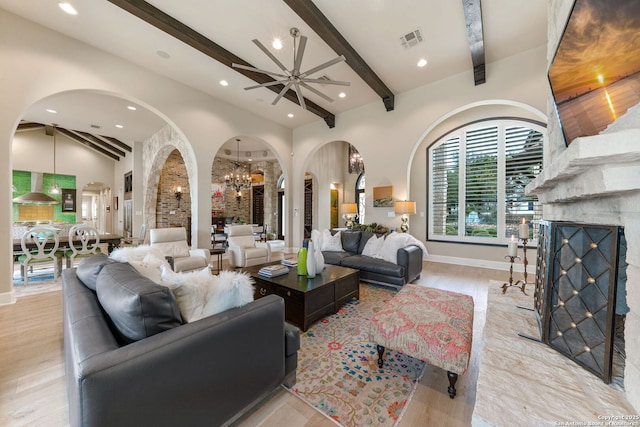 living room with a fireplace, recessed lighting, visible vents, wood finished floors, and beamed ceiling