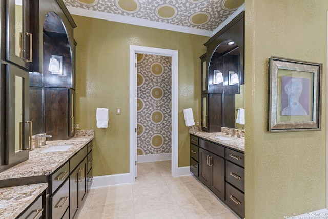 bathroom with baseboards, two vanities, a sink, and tile patterned floors