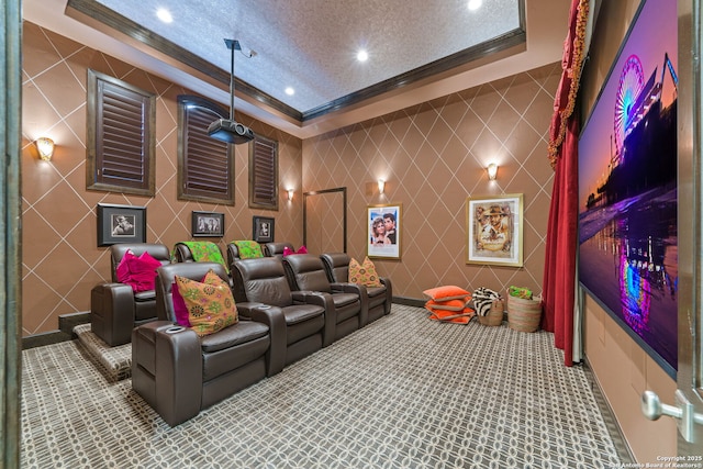 carpeted home theater featuring ornamental molding, recessed lighting, a raised ceiling, and a textured ceiling