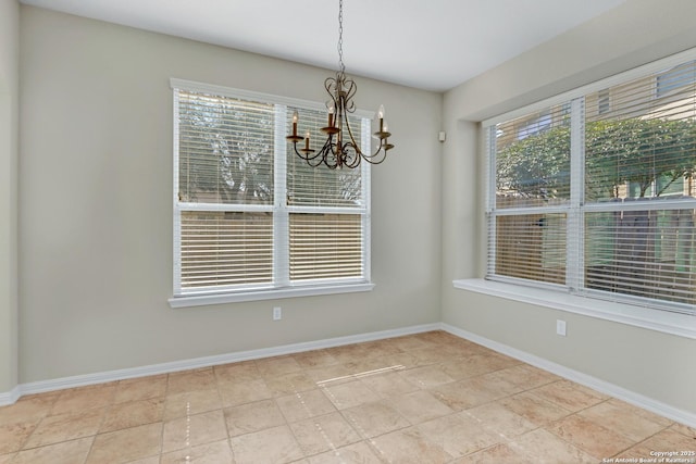 unfurnished dining area featuring an inviting chandelier, baseboards, and tile patterned floors