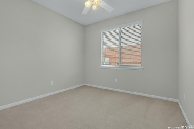 empty room with light carpet, a ceiling fan, and baseboards