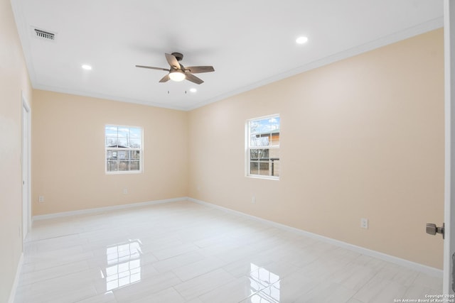 empty room featuring ceiling fan, a wealth of natural light, visible vents, and crown molding