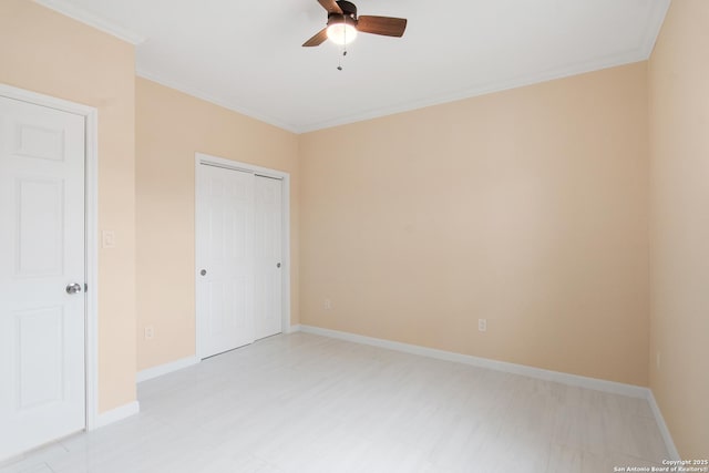 unfurnished bedroom with baseboards, ornamental molding, ceiling fan, and a closet