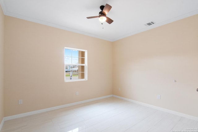 spare room featuring baseboards, a ceiling fan, visible vents, and crown molding