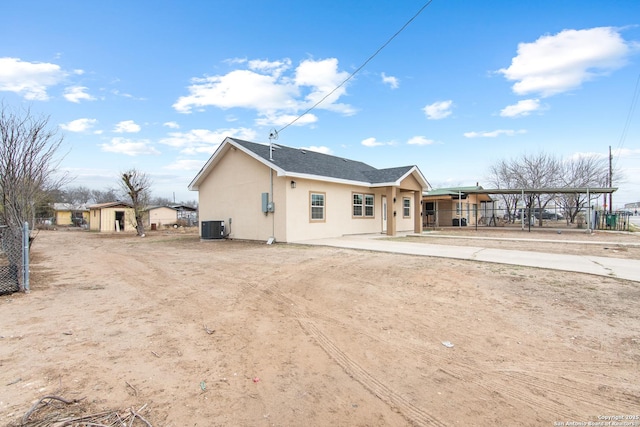 back of property featuring stucco siding, fence, and central air condition unit