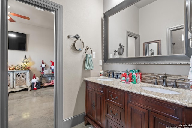 bathroom with a ceiling fan, a sink, finished concrete flooring, and double vanity