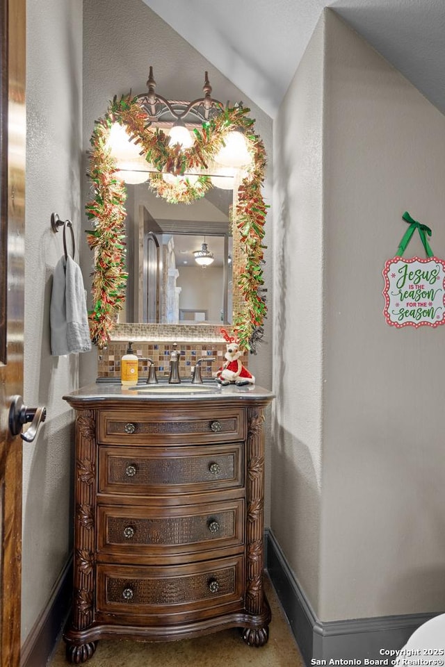 bathroom featuring backsplash, vanity, and baseboards