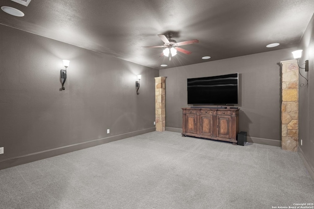 unfurnished living room with carpet floors, a textured ceiling, baseboards, and a ceiling fan