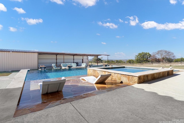 pool with a patio and an in ground hot tub