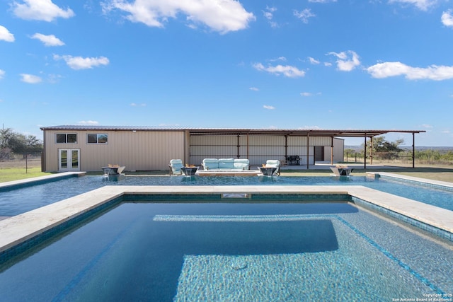 pool with an outbuilding, a patio area, an outdoor hangout area, and a storage structure