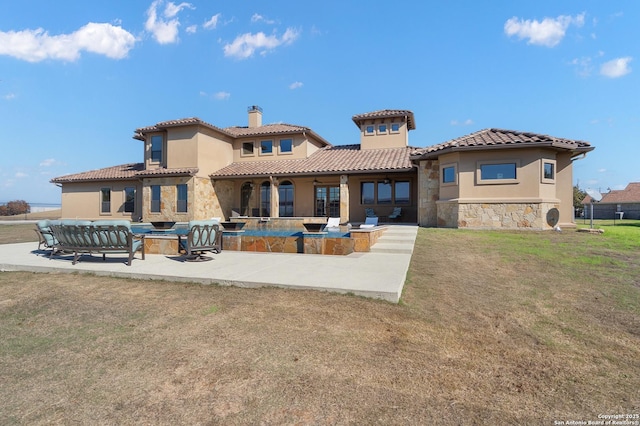 back of property featuring a patio area, a chimney, stone siding, and stucco siding