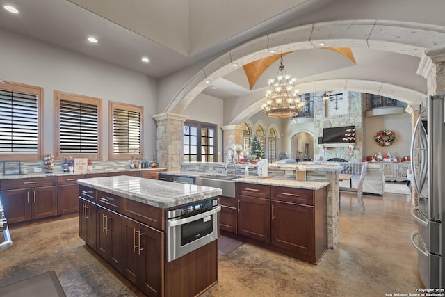 kitchen featuring recessed lighting, stainless steel appliances, a sink, open floor plan, and a center island with sink